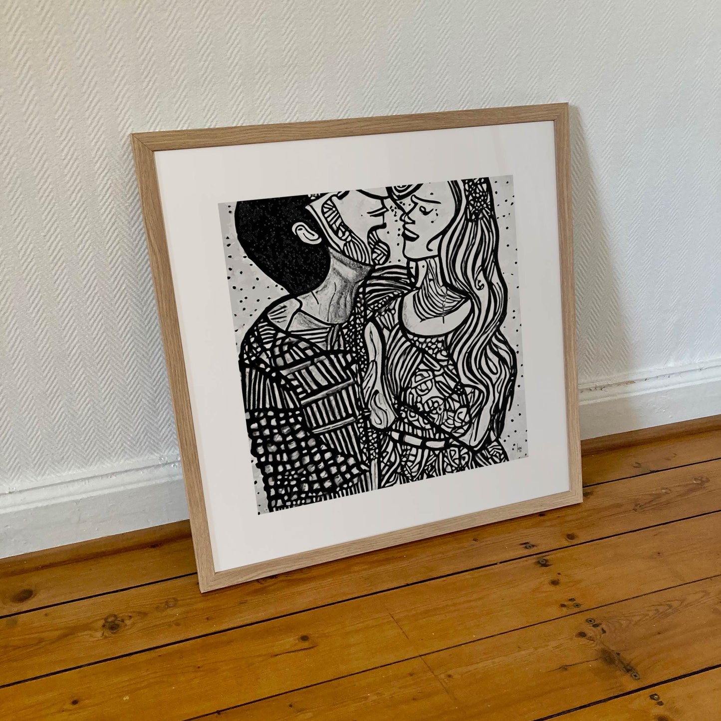 Tirage encadré 50×50 cm de "Pauline & Benjamin", portrait doux de deux amants abstraits, présenté dans un cadre bois clair sobre.