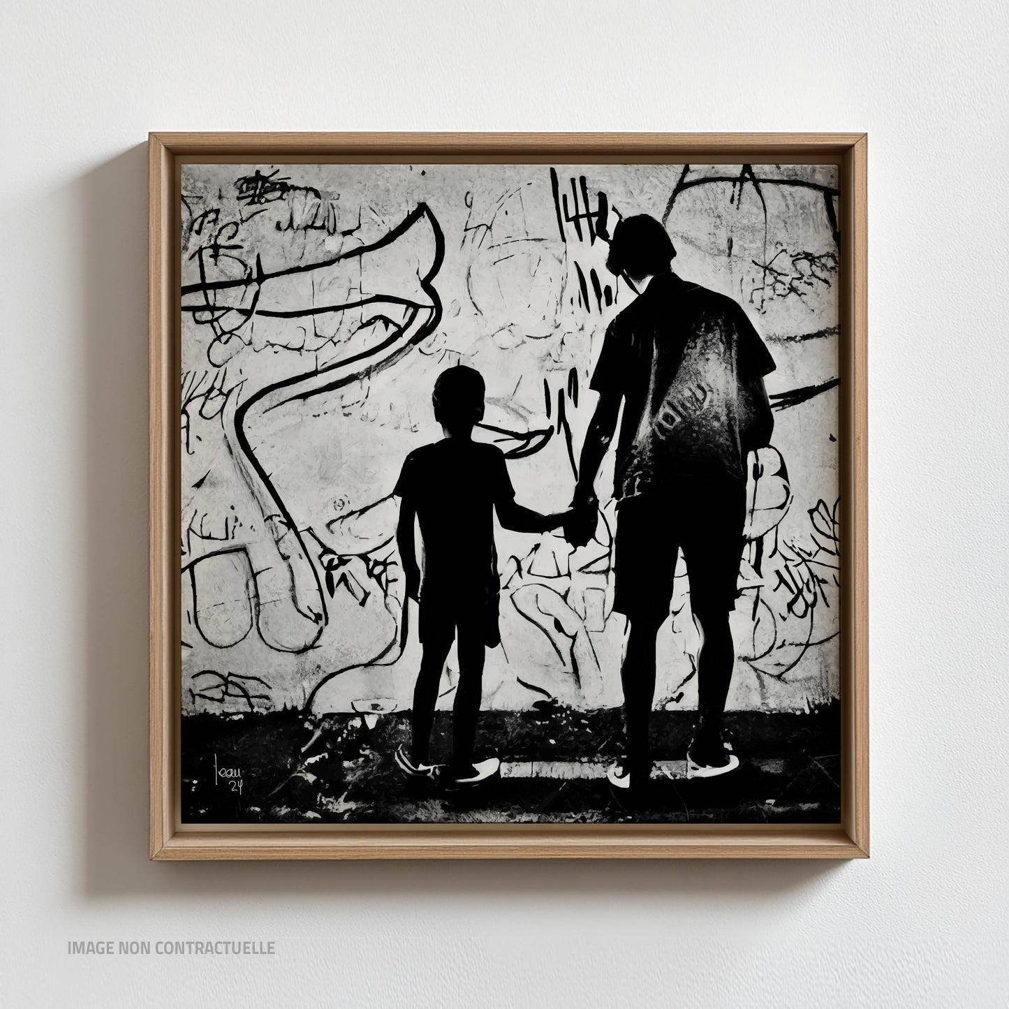 Œuvre "Paternité" sur caisse américaine 110×110 cm, duo de silhouettes en noir et blanc face à un mur artistique, encadrement sobre et élégant.