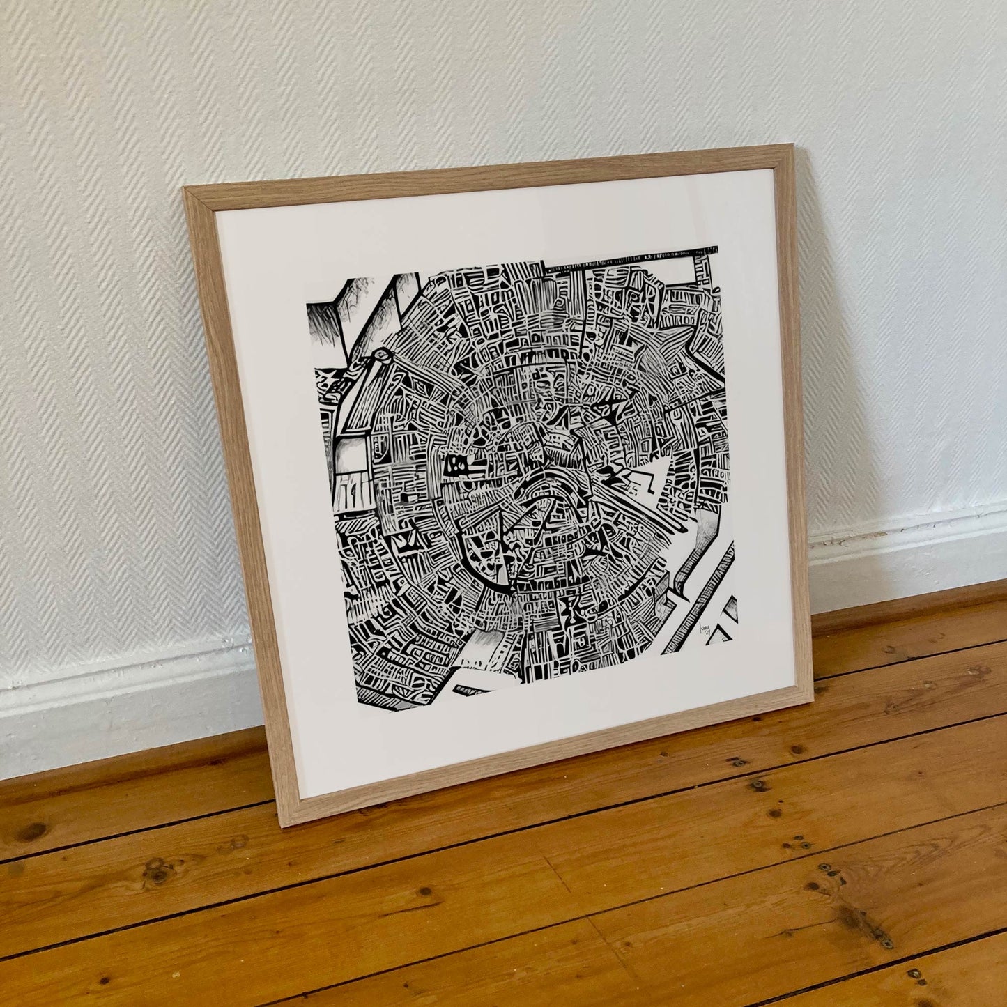 Œuvre "Matrice" encadrée au format 50×50 cm, dessin en noir et blanc aux formes denses et organiques, encadrement clair et minimaliste.