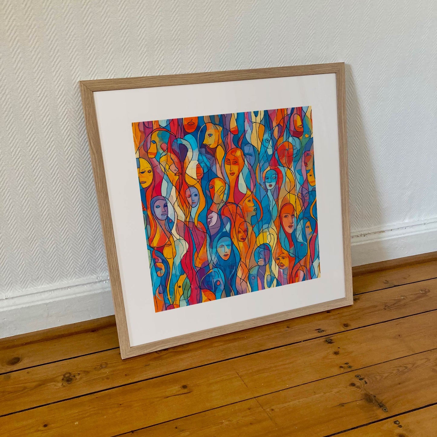 Œuvre 'EUX' encadrée en 50x50cm, mosaïque de visages colorés en bleu, orange, jaune, rouge, cadre en bois clair, style abstrait figuratif, 2025