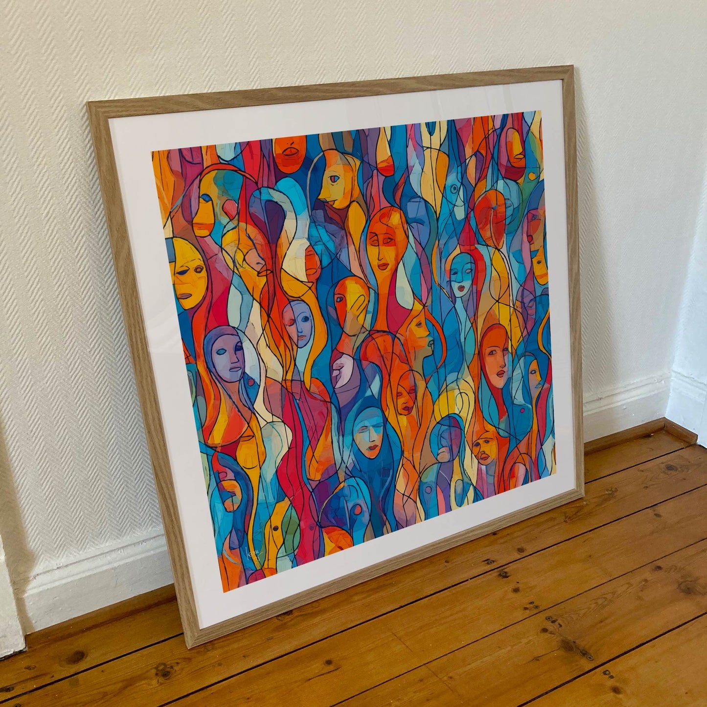 Œuvre 'EUX' encadrée en 70x70cm, visages colorés en bleu, orange, jaune, rouge avec lignes noires, cadre en bois clair, art expressif moderne, 2025