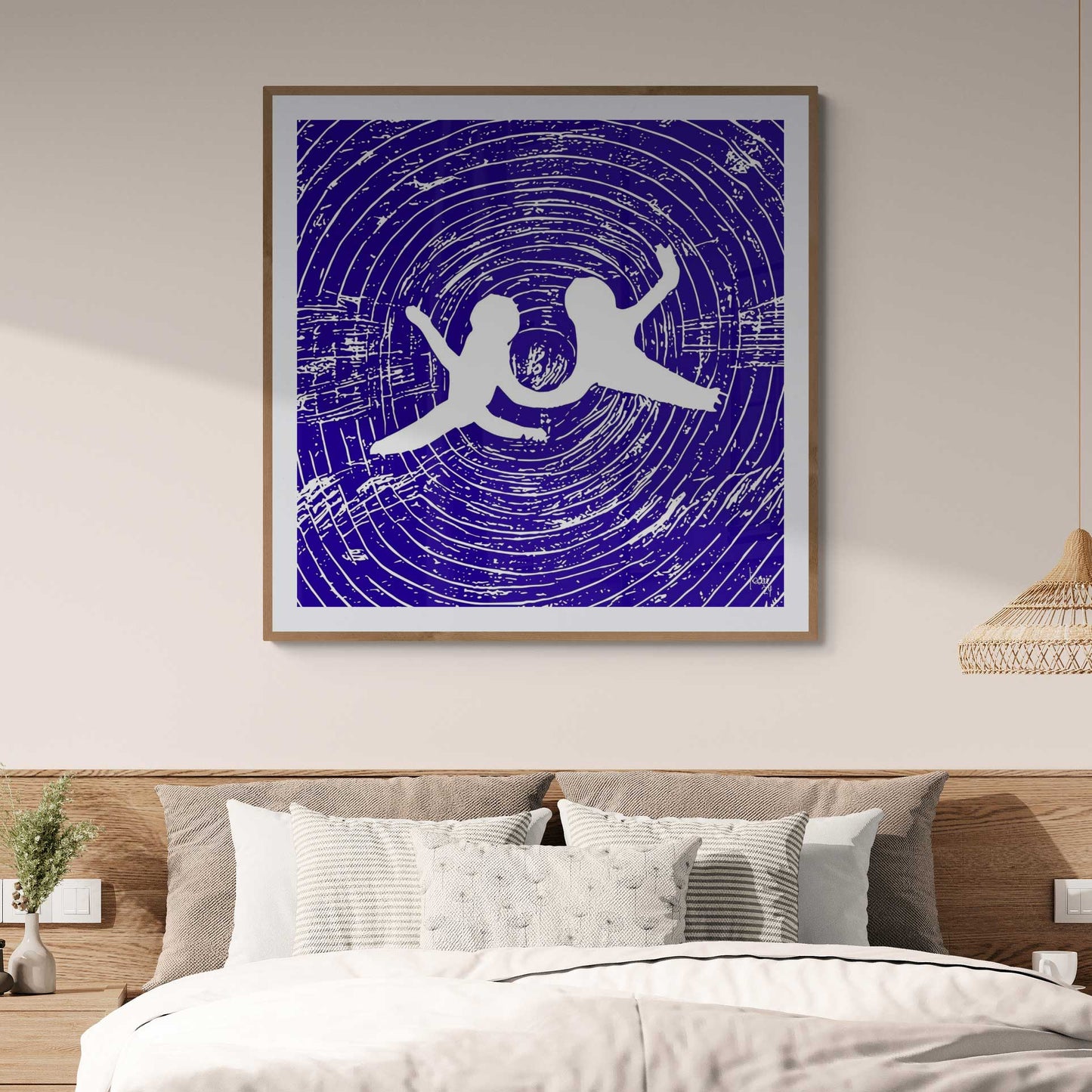 Œuvre 'ANGES' exposée sous cadre dans une chambre contemporaine, silhouettes blanches dans un vortex bleu, ajoutant une touche d'élégance abstraite à la décoration intérieure, 2024