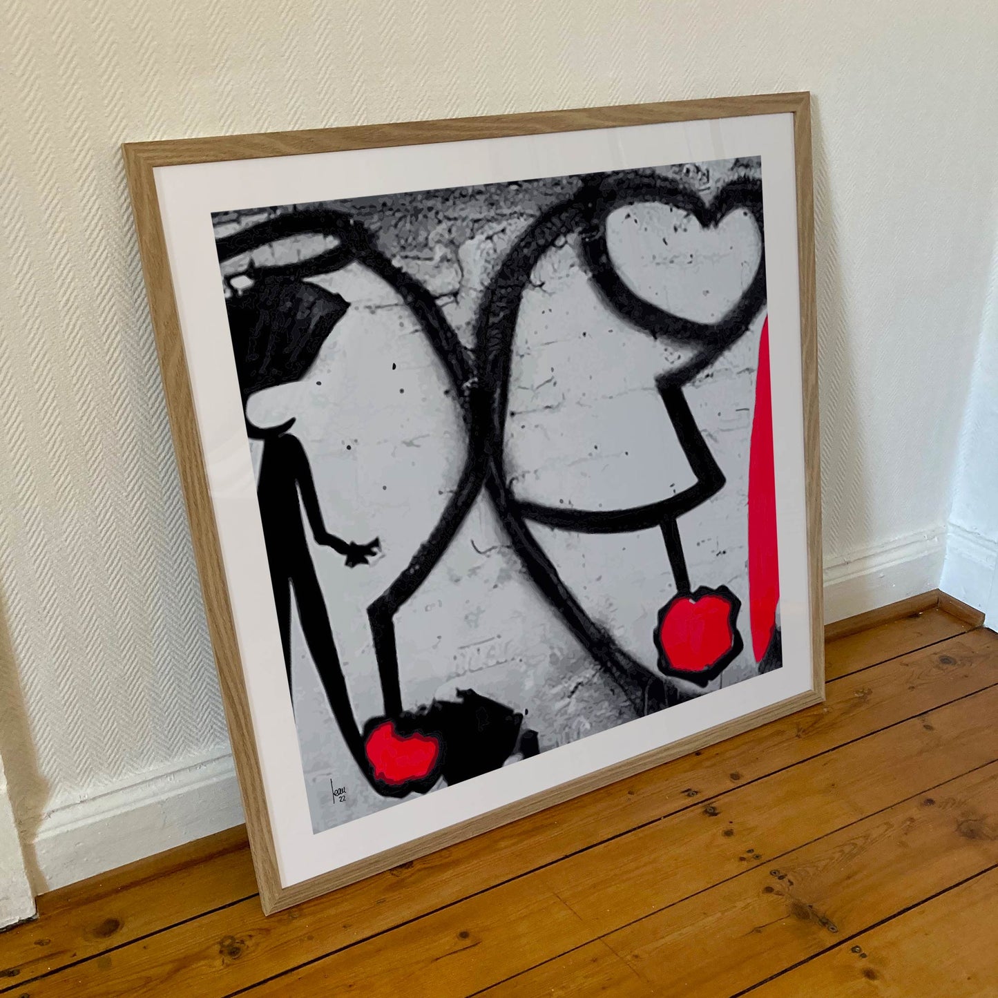 Œuvre "ATTACHES" encadrée en 70x70cm, traits noirs graphiques et rouges dans un cadre en bois clair avec verre acrylique, art contemporain minimaliste, 2022