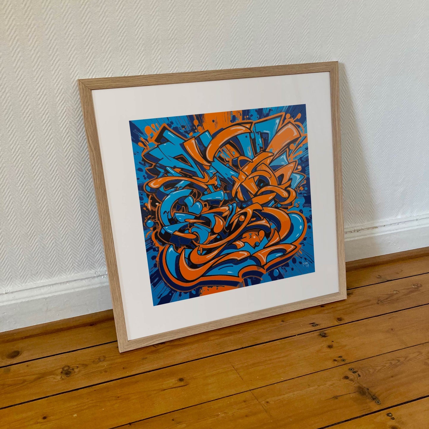 Œuvre 'EXPLOSION' encadrée en 50x50cm, motifs orange et bleu vibrants, cadre en bois clair, style graffiti abstrait moderne, 2024