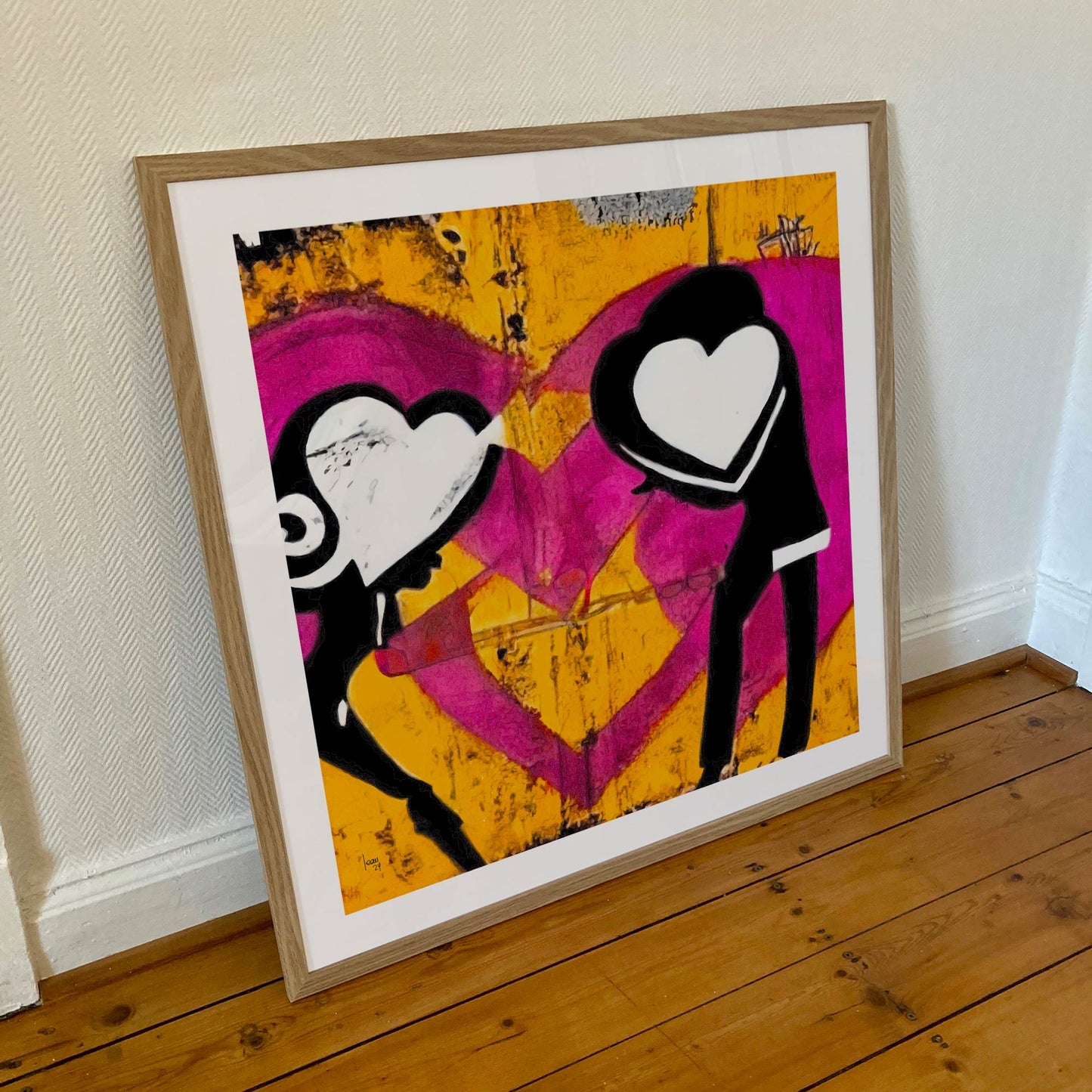 Œuvre 'ATTRACTION' encadrée en 70x70cm, silhouettes aux cœurs éclatants sur fond jaune et fuchsia, cadre en bois clair, style street art poétique, 2024