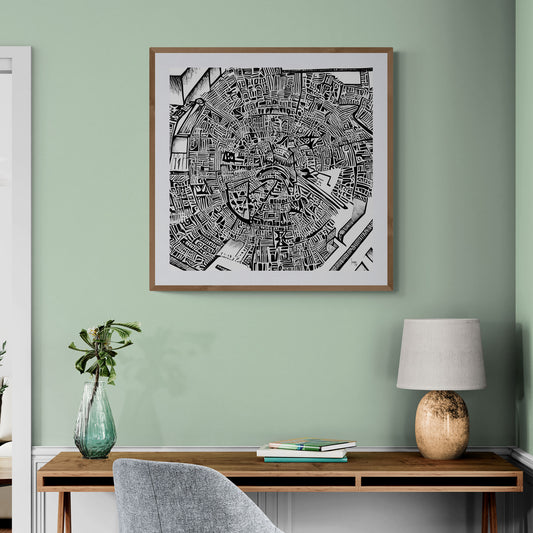 Mise en situation de l’œuvre "Matrice" encadrée dans un bureau contemporain, affichée sur un mur blanc, mettant en valeur son style graphique noir et blanc sophistiqué.