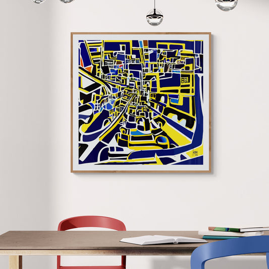 "Le Centre Ville", tirage d'art contemporain encadré abstrait d'un labyrinthe urbain aux couleurs bleues et jaunes, présenté dans un bureau